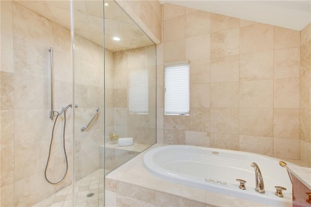 bathroom featuring lofted ceiling and independent shower and bath