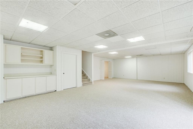 basement featuring light carpet and a drop ceiling