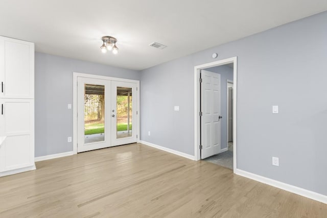 unfurnished room with french doors and light hardwood / wood-style flooring