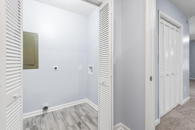 clothes washing area with electric dryer hookup, electric panel, washer hookup, and light wood-type flooring