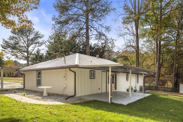 rear view of property featuring a lawn, cooling unit, and a patio