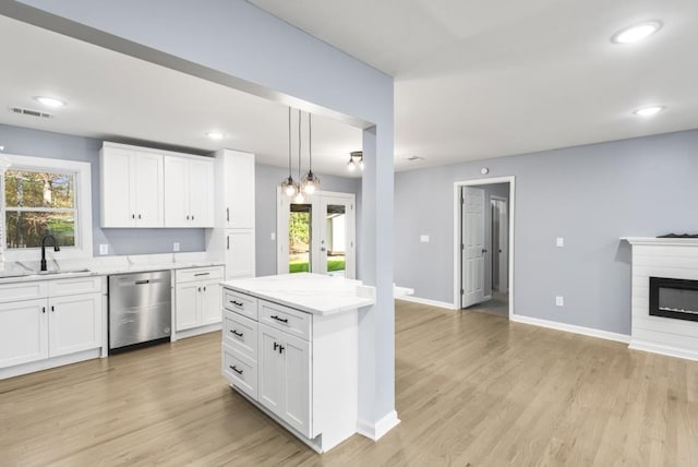 kitchen featuring dishwasher, light hardwood / wood-style floors, white cabinetry, and sink