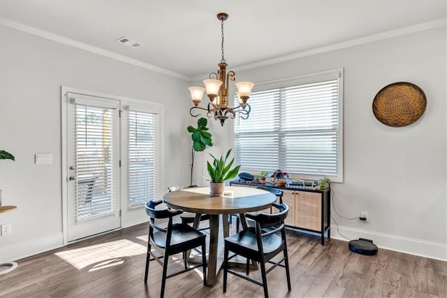 dining room with visible vents, crown molding, baseboards, an inviting chandelier, and wood finished floors