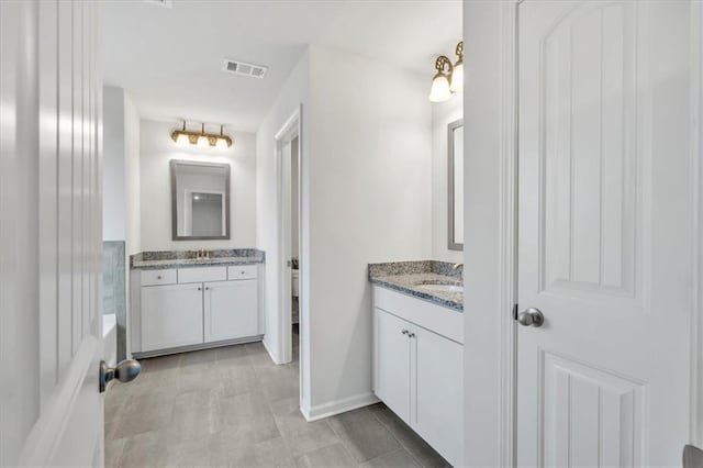 bathroom featuring a sink, visible vents, and two vanities