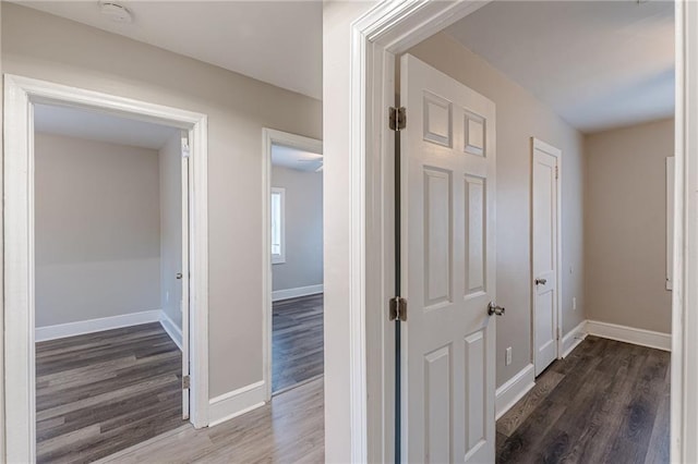 hall with baseboards and wood finished floors