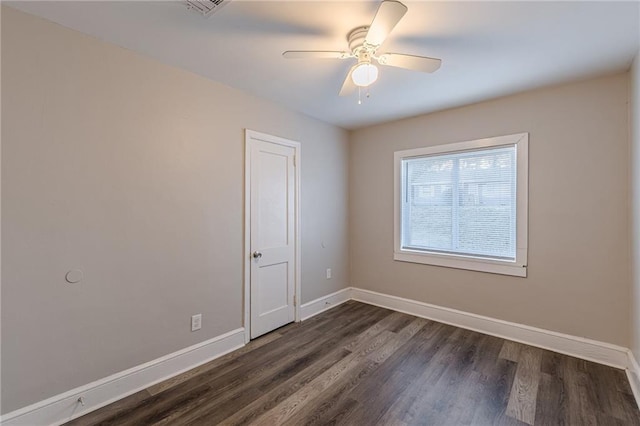 unfurnished room with visible vents, baseboards, dark wood finished floors, and a ceiling fan