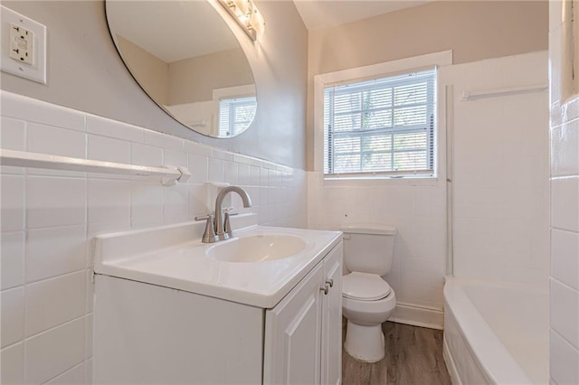 bathroom with tile walls, toilet, wainscoting, vanity, and wood finished floors