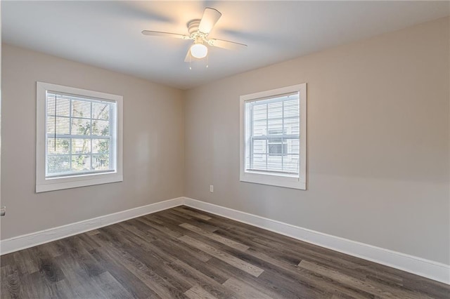 unfurnished room with a healthy amount of sunlight, a ceiling fan, baseboards, and dark wood-type flooring