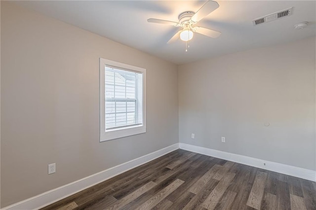 unfurnished room featuring ceiling fan, dark wood finished floors, visible vents, and baseboards