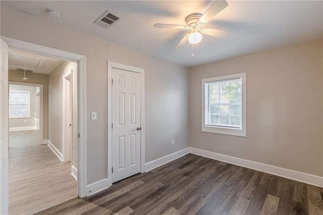 spare room with visible vents, dark wood-style flooring, attic access, and baseboards