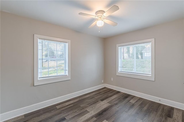 empty room with ceiling fan, baseboards, and dark wood-type flooring