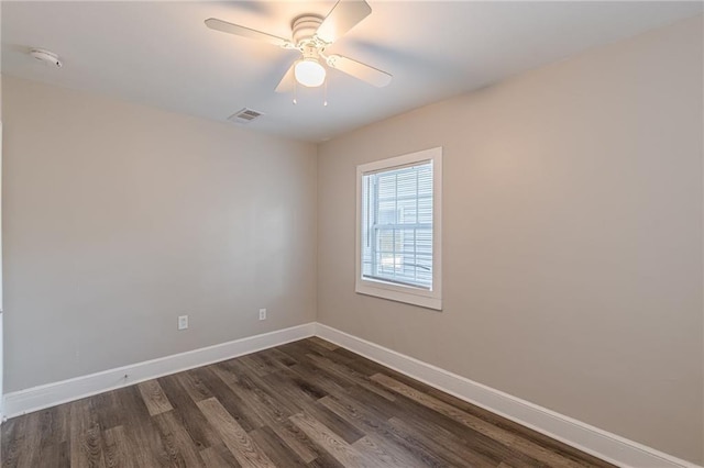 unfurnished room with visible vents, dark wood finished floors, baseboards, and ceiling fan