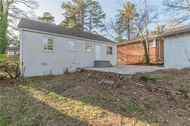 back of property with crawl space, a patio area, fence, and brick siding