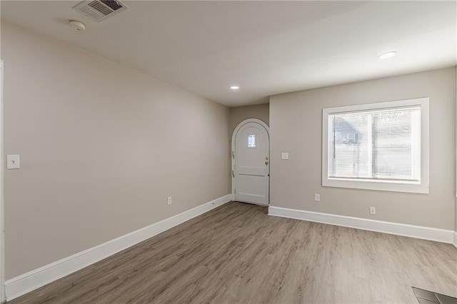 foyer entrance with light wood finished floors, baseboards, visible vents, and recessed lighting