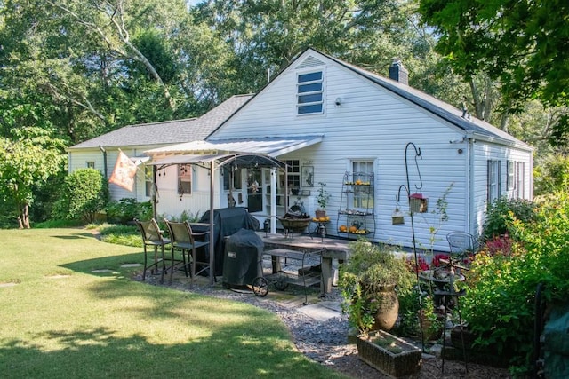 rear view of house featuring a yard