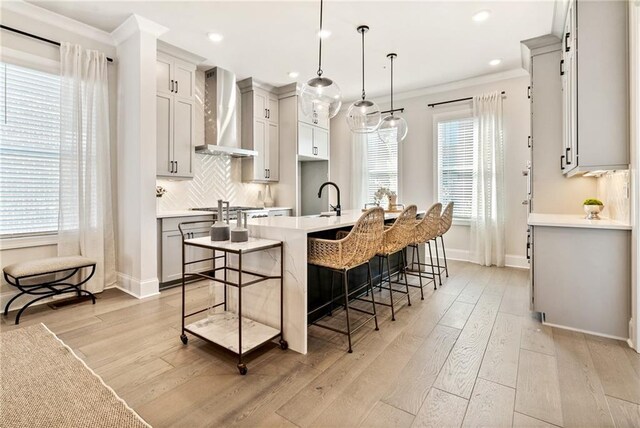 235 Briscoe Way Unit 7, Alpharetta, GA 30009 - kitchen featuring light wood finished floors, tasteful backsplash, crown molding, and wall chimney range hood