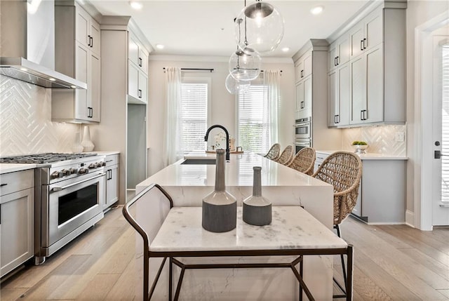 235 Briscoe Way Unit 7, Alpharetta, GA 30009 - kitchen featuring light wood finished floors, a sink, stainless steel appliances, light countertops, and wall chimney exhaust hood