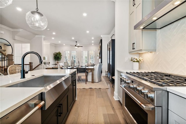 235 Briscoe Way Unit 7, Alpharetta, GA 30009 - kitchen featuring ornamental molding, light countertops, appliances with stainless steel finishes, wall chimney range hood, and decorative light fixtures