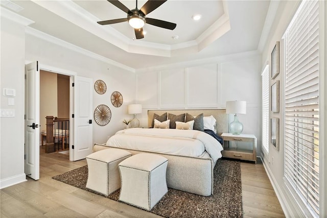 235 Briscoe Way Unit 7, Alpharetta, GA 30009 - bedroom featuring crown molding, a decorative wall, light wood-type flooring, and a tray ceiling