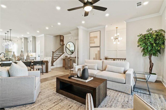 235 Briscoe Way Unit 7, Alpharetta, GA 30009 - living area with stairway, visible vents, light wood-style flooring, recessed lighting, and ceiling fan with notable chandelier