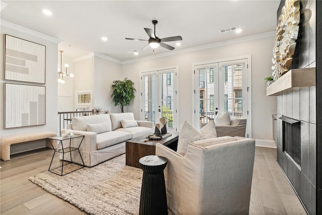 235 Briscoe Way Unit 7, Alpharetta, GA 30009 - living area featuring light wood finished floors, visible vents, ceiling fan with notable chandelier, and crown molding