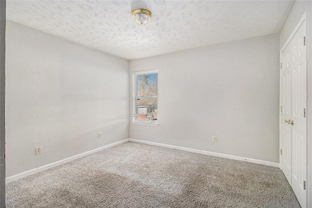 unfurnished bedroom featuring a closet, a textured ceiling, baseboards, and carpet flooring