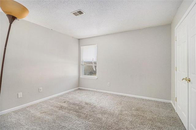 interior space with a textured ceiling, visible vents, and baseboards