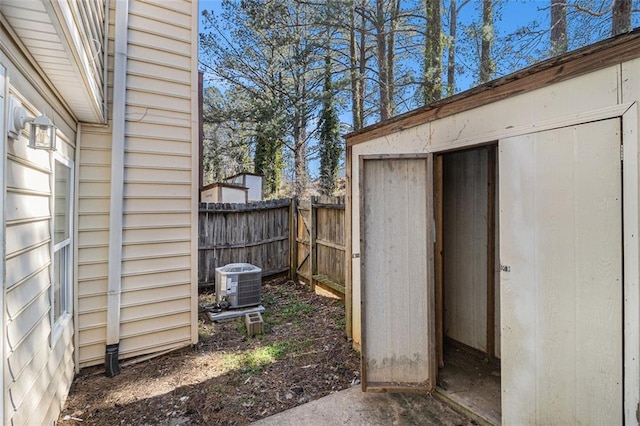 view of shed with fence and central air condition unit