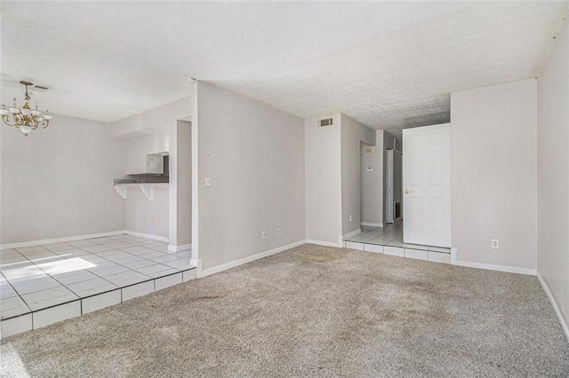 unfurnished living room with light carpet, baseboards, visible vents, a textured ceiling, and a chandelier