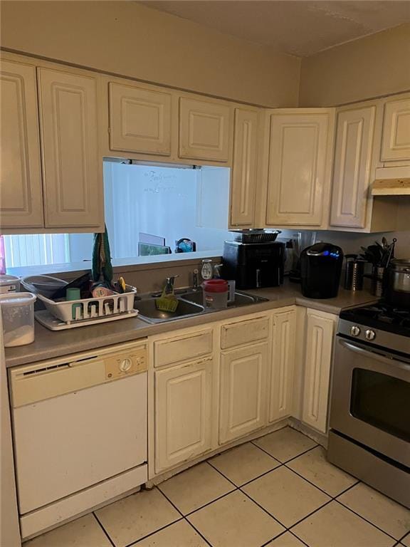 kitchen with sink, stainless steel stove, white cabinets, white dishwasher, and light tile patterned flooring