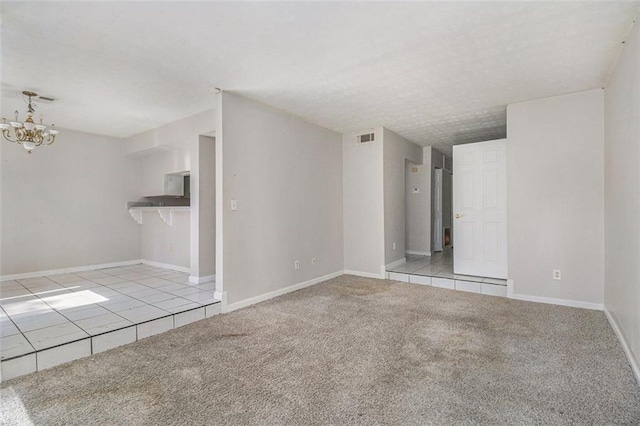 unfurnished living room featuring light tile patterned floors, baseboards, visible vents, light colored carpet, and an inviting chandelier