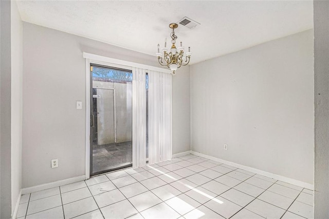 empty room featuring visible vents, a chandelier, baseboards, and light tile patterned flooring