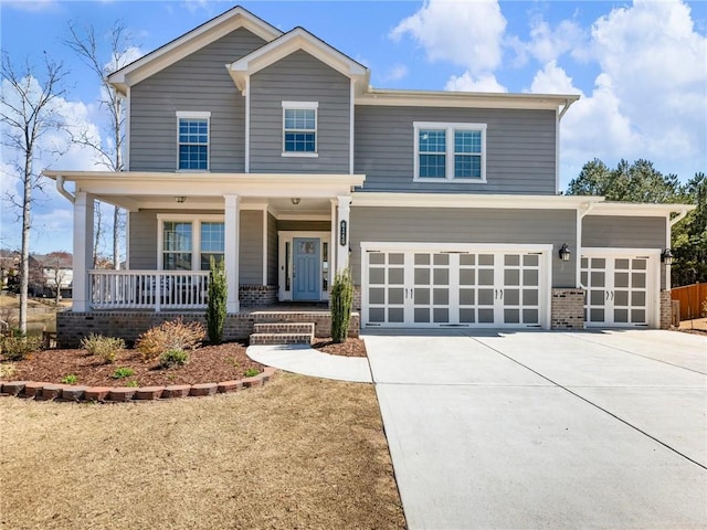 craftsman-style home featuring brick siding, covered porch, concrete driveway, and an attached garage