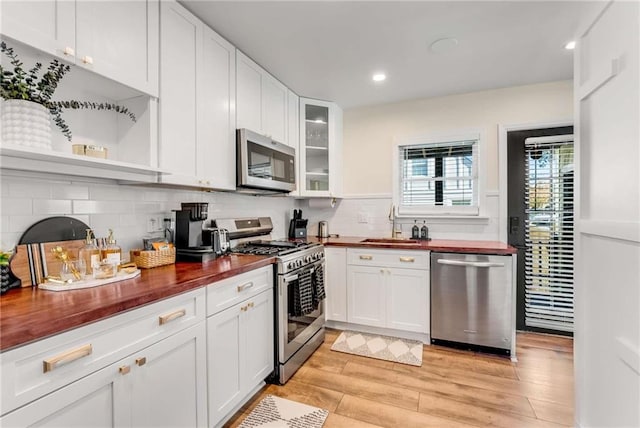 1471 Hardin Dr, College Park, GA 30337 - kitchen featuring appliances with stainless steel finishes, wood counters, white cabinetry, decorative backsplash, and recessed lighting