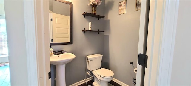 bathroom with a healthy amount of sunlight, toilet, and sink