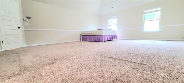 interior space featuring vaulted ceiling and carpet