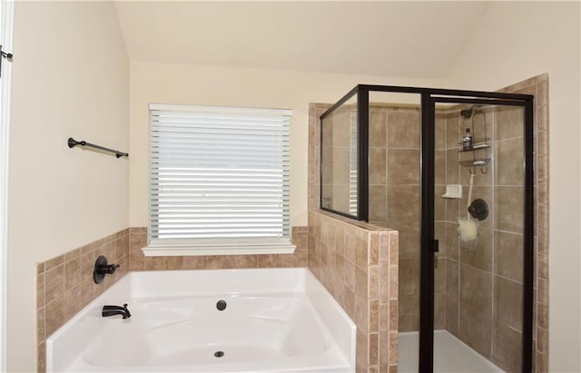 bathroom with shower with separate bathtub and vaulted ceiling