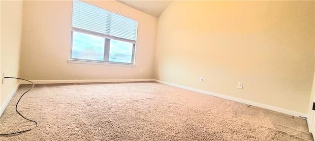 spare room featuring lofted ceiling and carpet