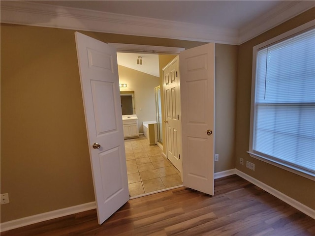 interior space featuring lofted ceiling, ornamental molding, and light hardwood / wood-style floors