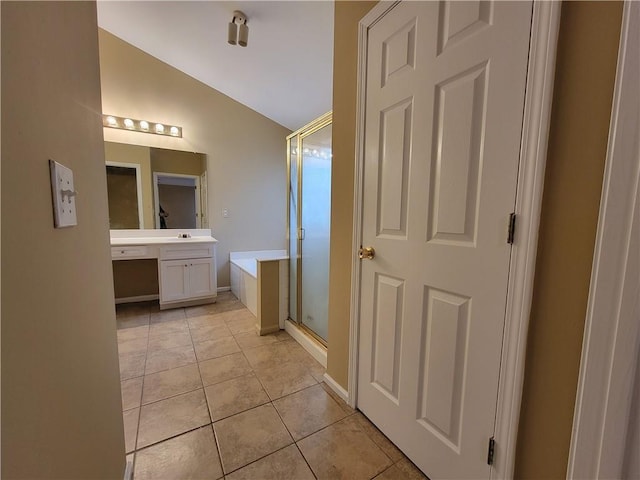 bathroom featuring vanity, shower with separate bathtub, tile patterned flooring, and vaulted ceiling