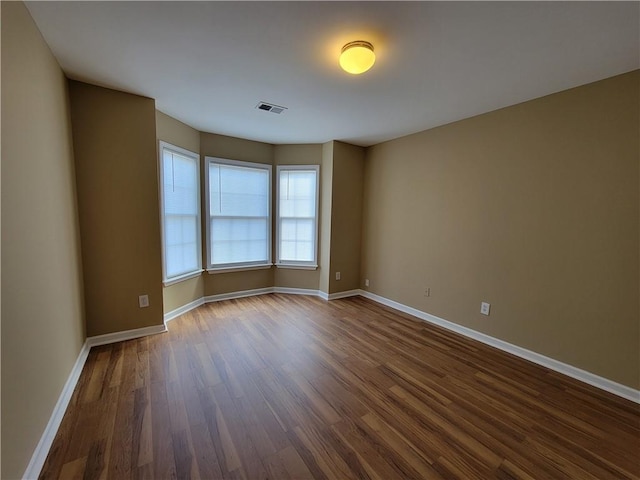 unfurnished room with dark wood-type flooring