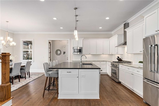 kitchen featuring ornamental molding, a sink, white cabinets, appliances with stainless steel finishes, and wall chimney range hood