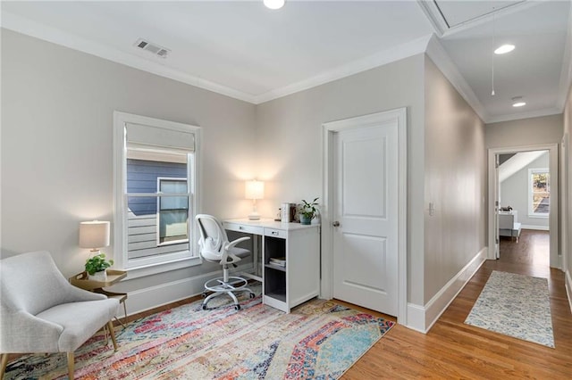 office space featuring visible vents, baseboards, attic access, ornamental molding, and wood finished floors