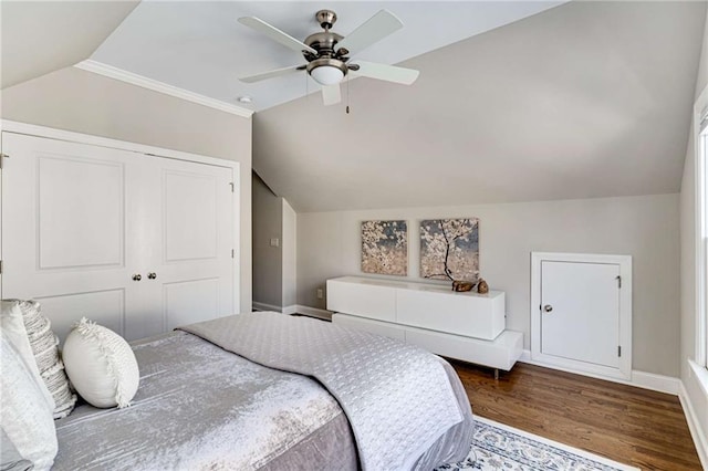 bedroom featuring a ceiling fan, wood finished floors, a closet, baseboards, and vaulted ceiling