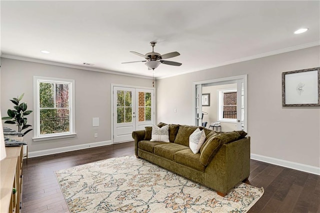 living room with a ceiling fan, baseboards, dark wood-type flooring, and crown molding