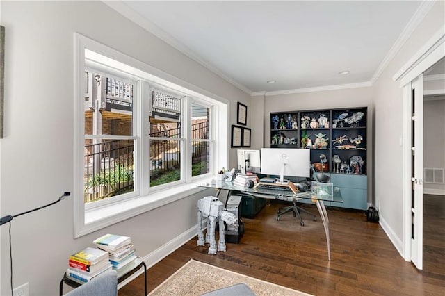 office space with visible vents, crown molding, baseboards, and wood finished floors