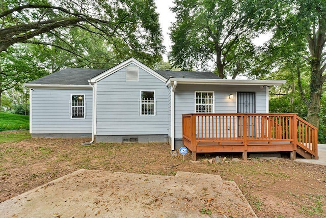 rear view of house with a wooden deck and a patio area
