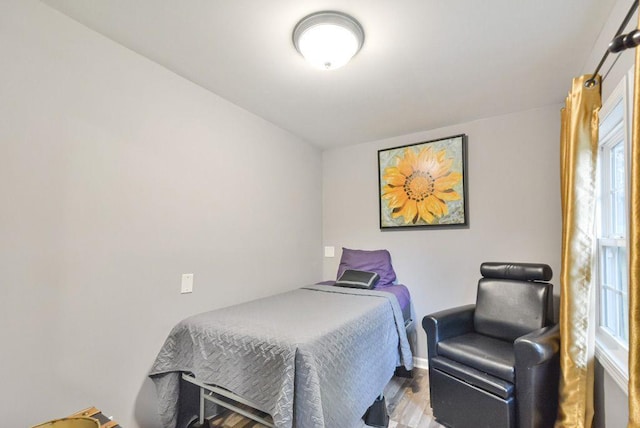 bedroom featuring baseboards and wood finished floors
