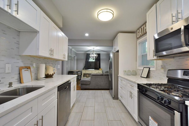 kitchen featuring tasteful backsplash, a healthy amount of sunlight, stainless steel appliances, and white cabinetry