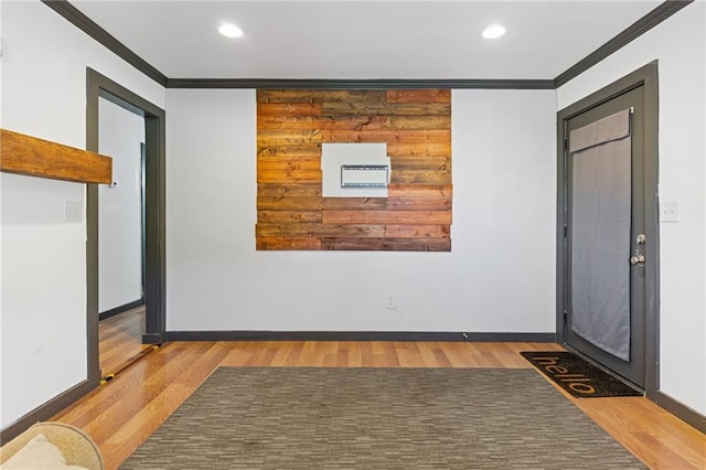 entryway with ornamental molding and hardwood / wood-style floors